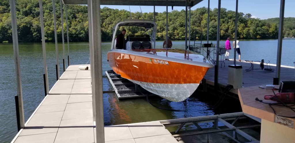Photo of a white and orange boat and a LOTO Lift boat lift.